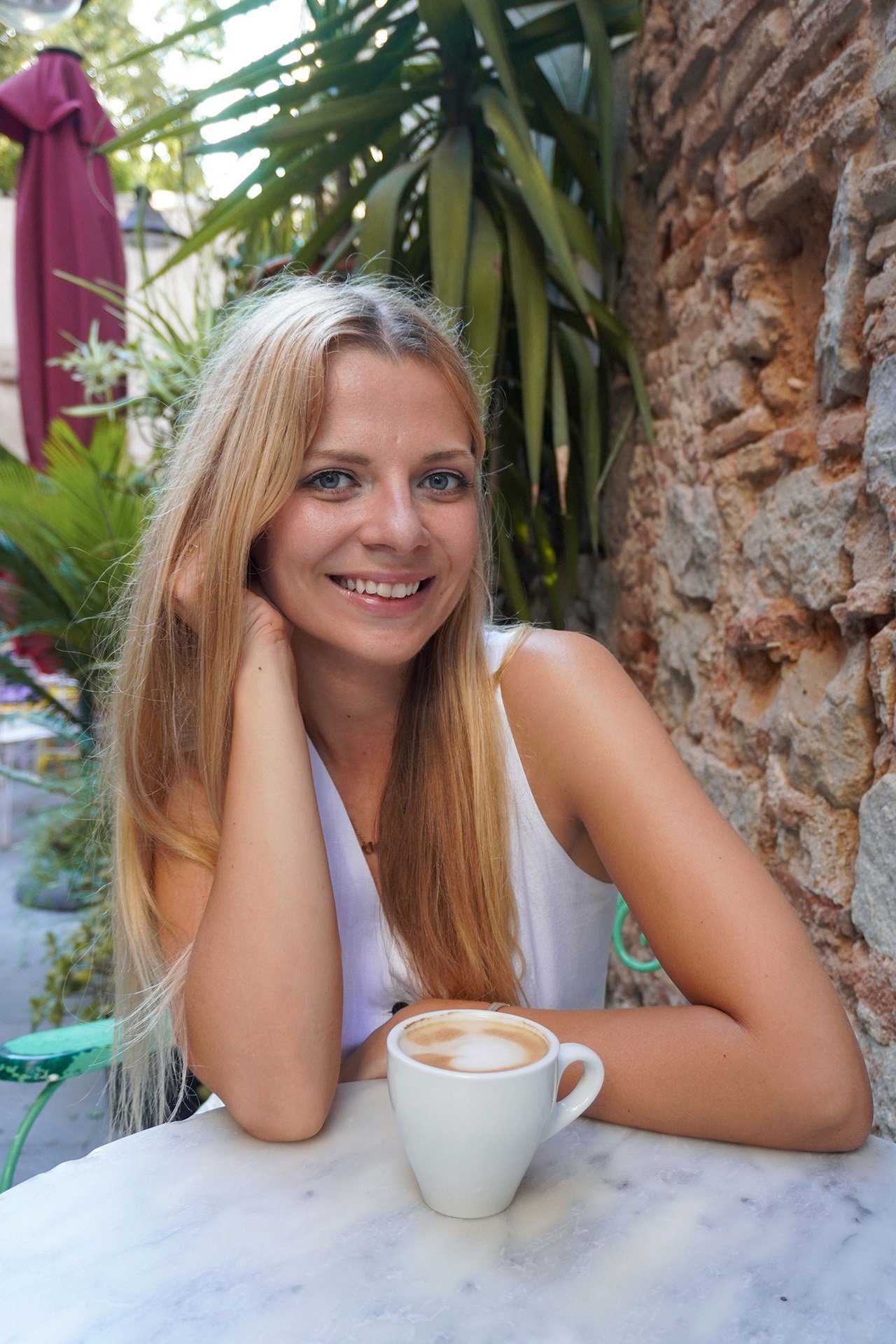 Joven rubia sonriendo en un campo de hierba alta